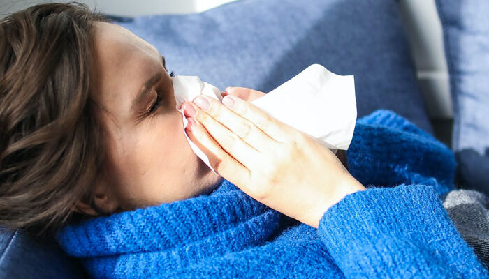 Flu season & Flu Treatments - Woman sneezing