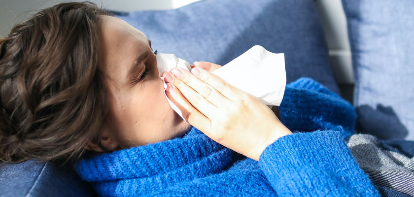 Flu season & Flu Treatments - Woman sneezing